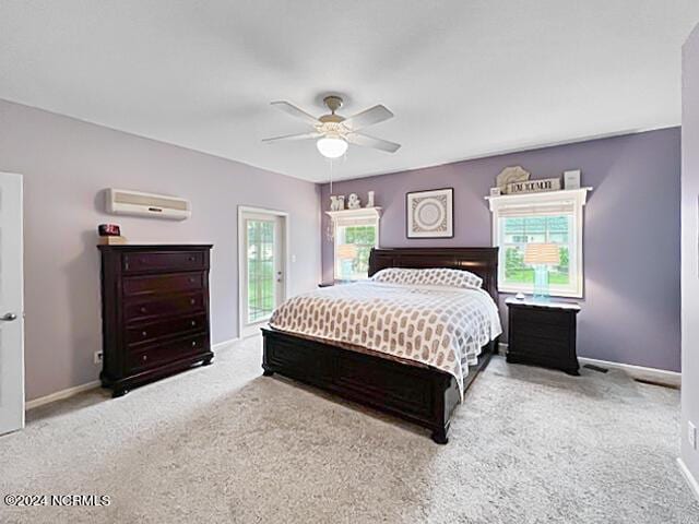 carpeted bedroom with ceiling fan, baseboards, access to outside, and an AC wall unit