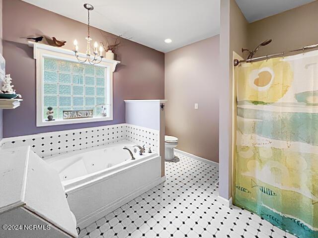 full bathroom with a notable chandelier, curtained shower, toilet, baseboards, and a tub with jets