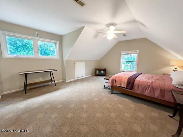 carpeted bedroom featuring baseboards, visible vents, vaulted ceiling, and a ceiling fan