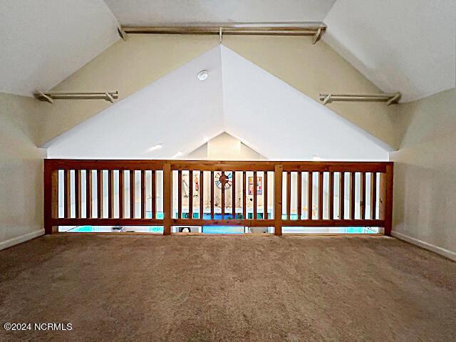 additional living space with vaulted ceiling and carpet floors