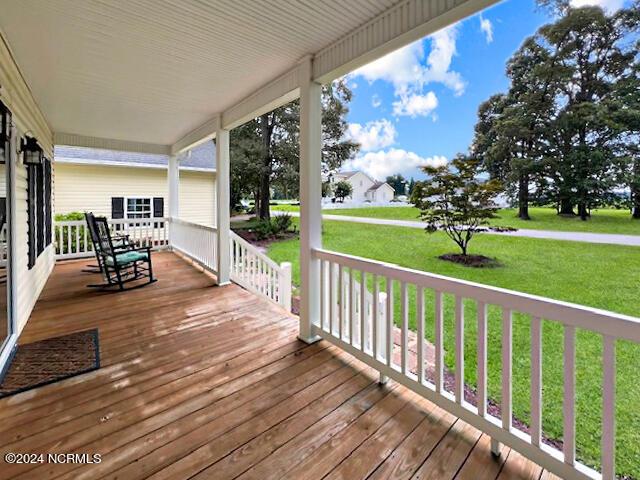 deck with a porch and a yard