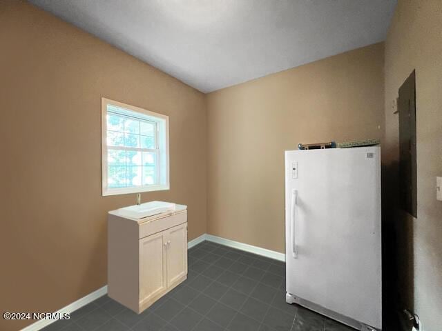 clothes washing area featuring a sink and baseboards