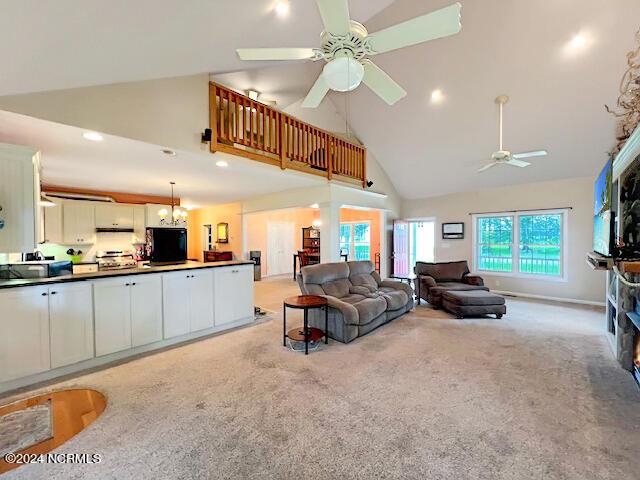 living area with a ceiling fan, recessed lighting, light carpet, and high vaulted ceiling