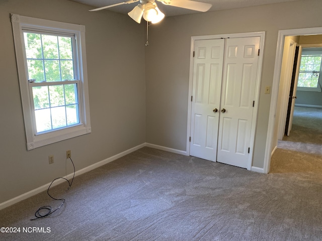 unfurnished bedroom featuring ceiling fan, a closet, carpet flooring, and baseboards