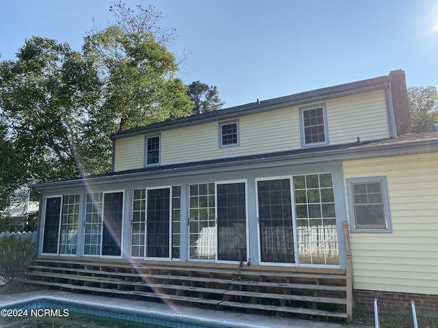 back of property featuring entry steps and a sunroom