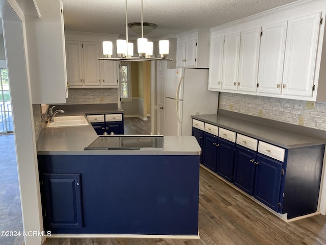 kitchen featuring blue cabinets, freestanding refrigerator, white cabinetry, and a sink