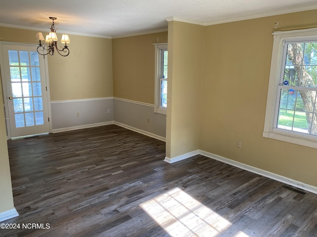 spare room featuring an inviting chandelier, plenty of natural light, visible vents, and dark wood-type flooring