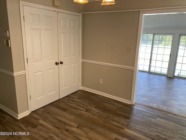 interior space featuring dark wood-style floors, baseboards, and a closet