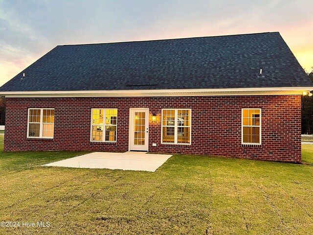 3701 Greystone Dr, Rocky Mount, NC 27804 - rear view of property with brick siding, a shingled roof, a patio, and a lawn