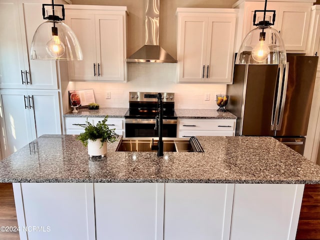 kitchen with stainless steel appliances, wall chimney range hood, a kitchen island with sink, and decorative backsplash