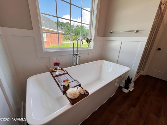3701 Greystone Dr, Rocky Mount, NC 27804 - bathroom featuring a soaking tub, wood finished floors, wainscoting, and a decorative wall