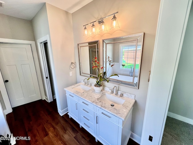 3701 Greystone Dr, Rocky Mount, NC 27804 - full bathroom featuring wood finished floors, double vanity, a sink, and baseboards