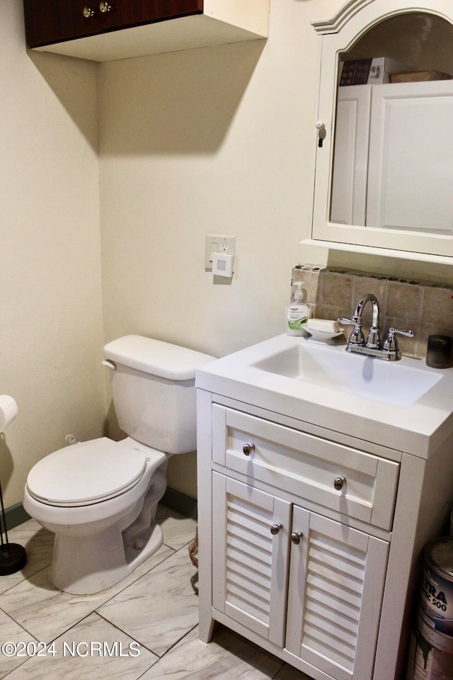 bathroom with toilet, tasteful backsplash, and vanity