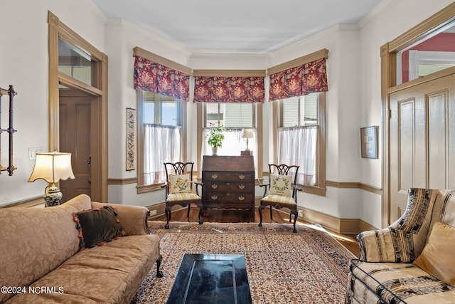 sitting room with baseboards, ornamental molding, a wealth of natural light, and wood finished floors