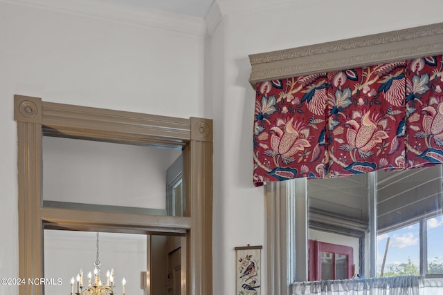 interior details with a notable chandelier and crown molding