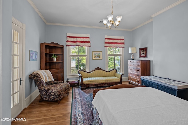 bedroom featuring baseboards, crown molding, a chandelier, and wood finished floors