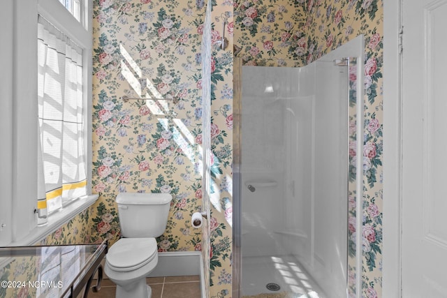 full bath featuring a stall shower, tile patterned floors, toilet, and wallpapered walls