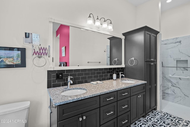 bathroom with double vanity, backsplash, a sink, and toilet