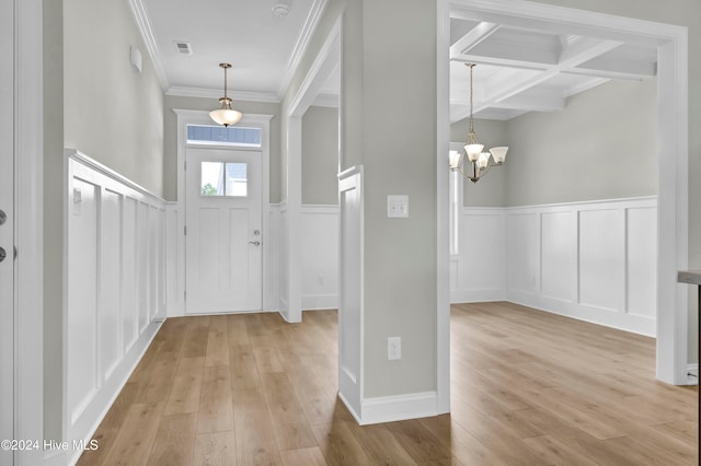 entryway featuring a notable chandelier, coffered ceiling, ornamental molding, beamed ceiling, and light wood-type flooring