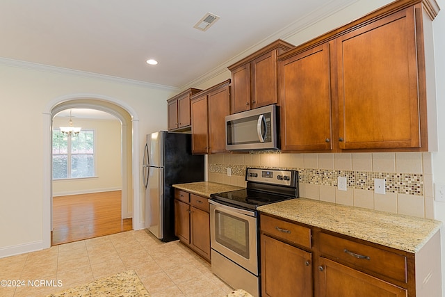 kitchen featuring backsplash, light stone counters, a chandelier, light tile patterned floors, and stainless steel appliances