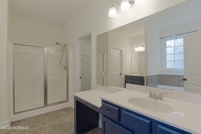 bathroom featuring tile patterned flooring, plus walk in shower, and vanity