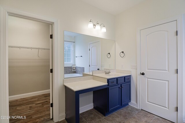 bathroom featuring hardwood / wood-style flooring, a bathing tub, and vanity