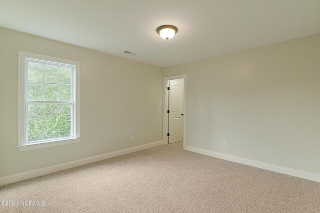 unfurnished room featuring light carpet