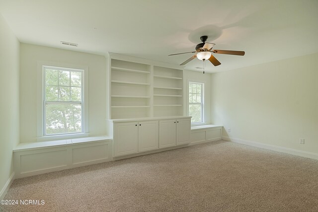 empty room featuring ceiling fan and light carpet