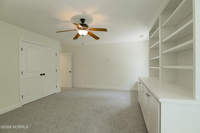 interior space featuring ceiling fan and light colored carpet