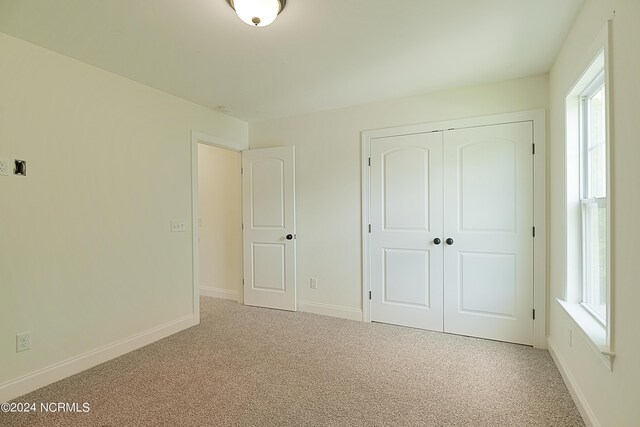 unfurnished bedroom featuring a closet and carpet floors