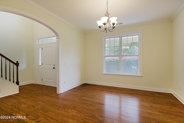 unfurnished room featuring hardwood / wood-style floors, ornamental molding, and a chandelier