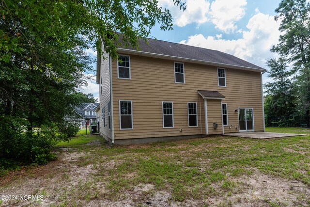 rear view of house with a yard and a patio