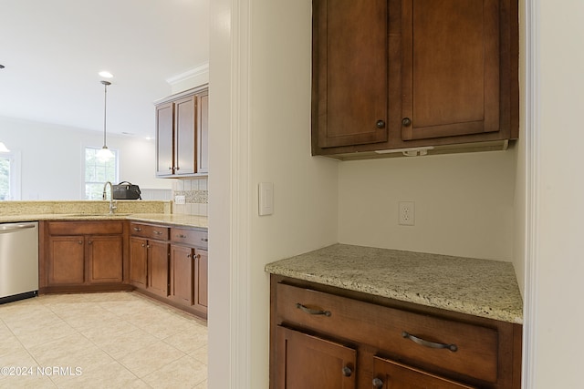 kitchen featuring decorative light fixtures, stainless steel dishwasher, sink, light stone countertops, and light tile patterned floors