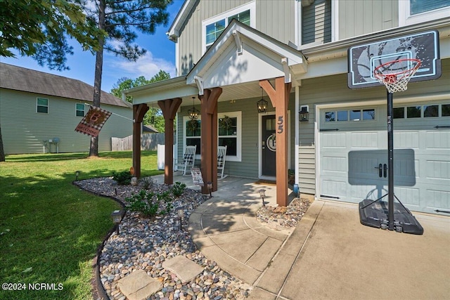 property entrance featuring a lawn, covered porch, and a garage