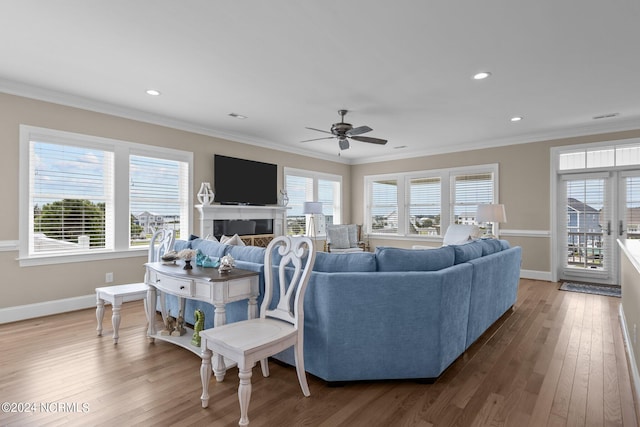 living room with hardwood / wood-style flooring, crown molding, and ceiling fan