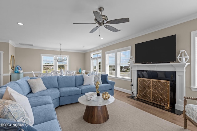 living room featuring light wood-type flooring, crown molding, and ceiling fan