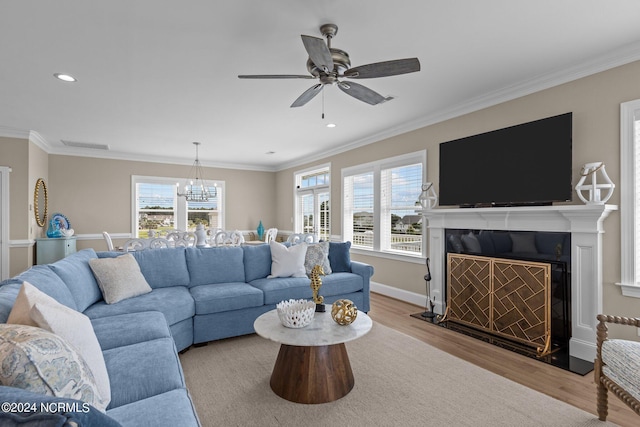 living area with recessed lighting, a fireplace, wood finished floors, baseboards, and crown molding