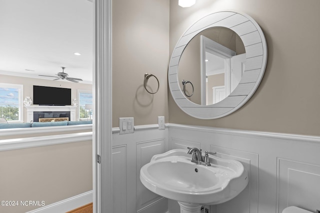 bathroom with ceiling fan, sink, and ornamental molding