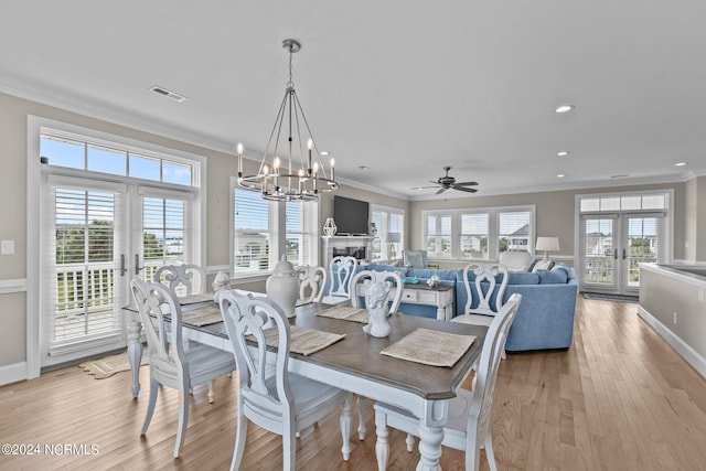 dining space featuring crown molding, light hardwood / wood-style flooring, and french doors