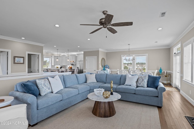 living room with light hardwood / wood-style flooring, crown molding, and ceiling fan with notable chandelier