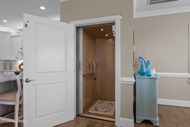 bathroom featuring baseboards, visible vents, ornamental molding, wood finished floors, and recessed lighting