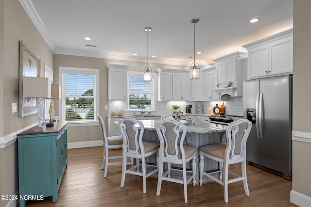 kitchen featuring wood finished floors, white cabinets, stainless steel fridge with ice dispenser, tasteful backsplash, and crown molding