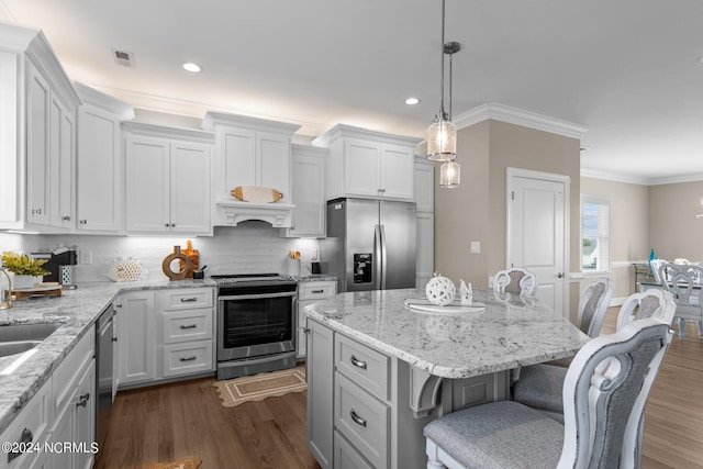 kitchen featuring stainless steel appliances, dark wood-style flooring, a kitchen bar, and visible vents