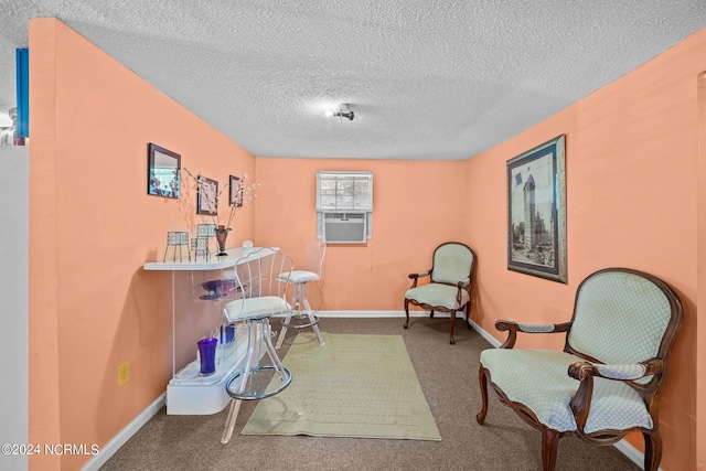 living area featuring cooling unit, carpet, baseboards, and a textured ceiling