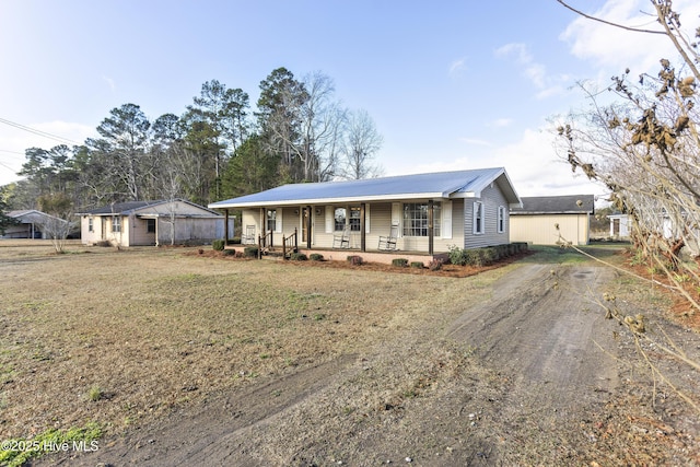 ranch-style house featuring a porch and an outbuilding