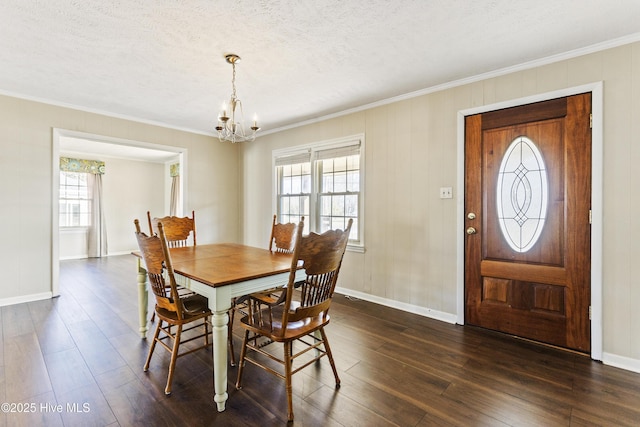 dining space with crown molding, dark wood-type flooring, a textured ceiling, and an inviting chandelier