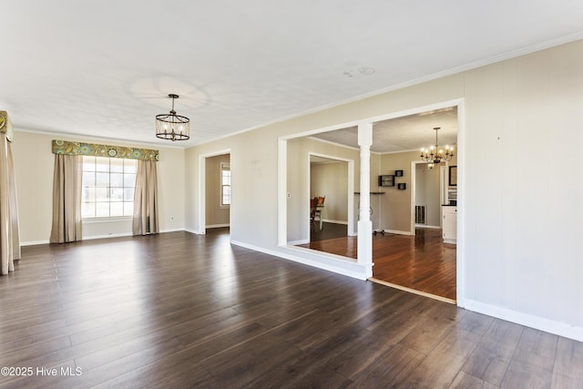 spare room featuring dark hardwood / wood-style flooring, ornamental molding, and ornate columns