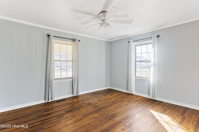 empty room with ceiling fan, a healthy amount of sunlight, crown molding, and dark wood-type flooring