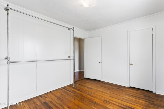 unfurnished bedroom featuring dark hardwood / wood-style floors and crown molding