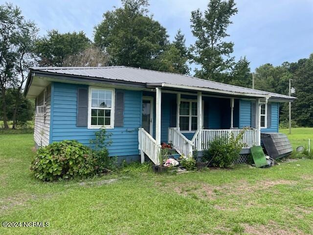 view of front of house with metal roof, a front lawn, and a porch